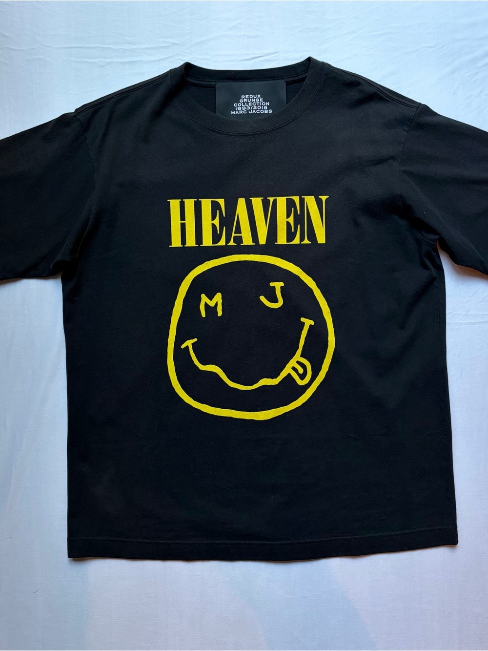 Marc Jacobs black tee with yellow HEAVEN smile graphic